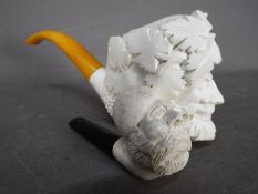 Two meerschaum pipes, the larger example modelled as Bacchus.