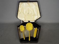 A cased four piece silver and enamel dressing table set comprising hand mirror, hair brush,