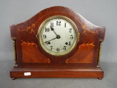 A mantel clock with inlaid decoration, Arabic numerals to a silvered dial, approximately 28 cm (h).