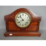 A mantel clock with inlaid decoration, Arabic numerals to a silvered dial, approximately 28 cm (h).