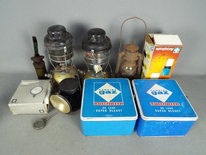 Lot to include vintage camping stoves, oil lamps and an Acme powder blower.