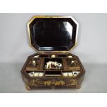 An Oriental lacquered box with fitted interior raised on four gilt supports,