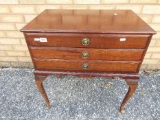 A mahogany three-drawer cabinet containing a good quantity of Walker & Hall cutlery,