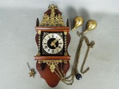 A Zaan type wall clock with two weights and pendulum.