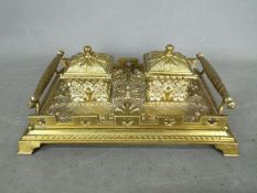 A Victorian solid brass desk top double inkstand in a Gothic Revival style with quatrefoil motifs,