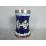 A Doulton ceramic vase decorated with metal ring,