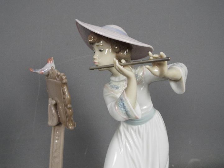 Lladro - A boxed figurine # 6093 'Songbird', depicting a young girl playing the flute, - Image 3 of 4