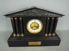 A mantel clock of architectural form with pendulum.