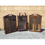 A Georgian mahogany hanging corner cupboard with glazed panel door set beneath swan necked pediment,