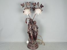 A large, twin light, figural table lamp with pink glass shades, approximately 77 cm (h).