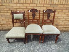 A pair of chairs with carved detailing a