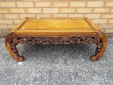 A Chinese coffee table, decorated with carved prunus (one carved end panel is detached),