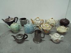 Tea Pot Collector - Left to right in rows description = Elkington art deco metal wood handle,