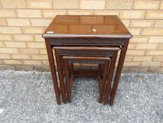 A nest of three tables with carved detailing, largest approximately 66 cm x 51 cm x 40 cm.