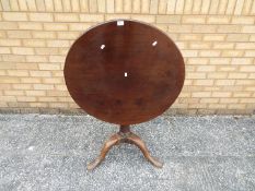 A circular tilt top, mahogany table, approximately 71 cm x 74 cm.