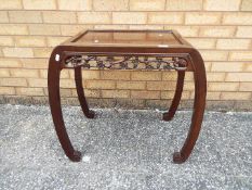 A Chinese side table with decoration of carved prunus, approximately 60 cm x 67 cm x 41 cm.