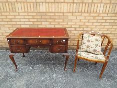 A leather topped mahogany desk on cabriole supports,