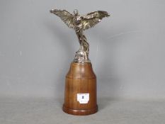 Automobilia - A Finnigans Icarus car mascot designed by Colin George, mounted to wooden plinth,