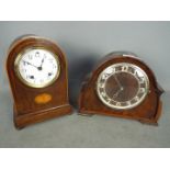 Two mantel clocks, a dome top example by Ansonia Clock Co and a Guta example.