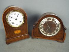 Two mantel clocks, a dome top example by Ansonia Clock Co and a Guta example.