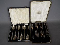 Two cased sets of hallmarked silver cutlery comprising a George VI set of six coffee spoons,