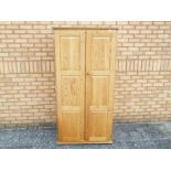 A pine twin door wardrobe measuring approximately 181 cm x 82 cm x 57 cm.