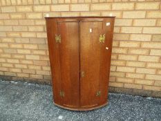 A Georgian cylinder front, wall mounted corner cabinet, approximately 93 cm x 61 cm x 40 cm