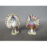 A matched pair of hand painted porcelain figures depicting Peacocks, likely Meissen,