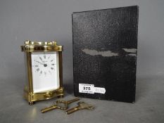 A French 8 day carriage clock in serpentine front, lacquered brass case,