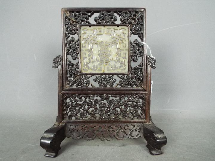 A carved wood and jade table screen,