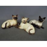 Beswick - Three Beswick cat figurines, all recumbent Siamese, largest approximately 12 cm (h).