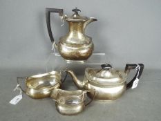 A George V hallmarked silver tea service comprising teapot, hot water jug, sugar bowl and cream jug,