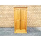 A pine single door wardrobe with lower drawer, approximately 183 cm x 89 cm x 52 cm.