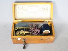 An Improved Magneto-Electric Machine in wooden case, approximately 12 cm x 25 cm x 12 cm.