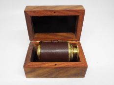 A brass and leather bound mini telescope,