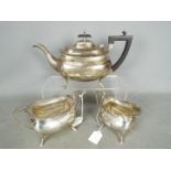 A George V hallmarked silver tea service comprising tea pot, cream jug and sugar bowl,