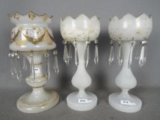 A pair of milk glass table lustres with gilt decoration (heavily rubbed) and one further similar