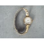 A 9ct gold cased lady's wristwatch on a rolled gold and stainless steel expanding bracelet,