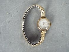 A 9ct gold cased lady's wristwatch on a rolled gold and stainless steel expanding bracelet,