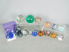 A collection of paperweights to include Mdina and similar.