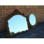 Two gilt framed oval mirrors, the larger one being approx 117 cm x 112 cm,