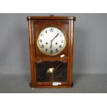 A HAC oak cased wall clock with key and pendulum.