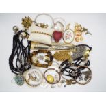 A collection of costume jewellery including bangles, necklaces, shell cameos, brooches and similar.