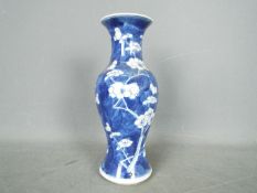 A Chinese blue and white vase with flared rim, decorated with prunus,