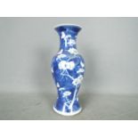 A Chinese blue and white vase with flared rim, decorated with prunus,