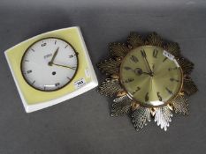 A pottery cased Hettich wall clock in yellow and white,