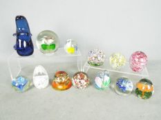 A collection of glass paperweights to include Mdina and similar.
