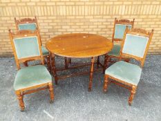 A oak drop leaf table and four upholstered chairs, table approximately 72 cm x 119 cm x 48 cm.