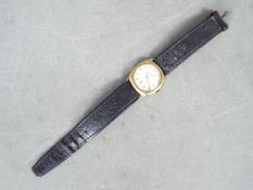 A gentleman's 9ct gold cased wristwatch, the dial signed Freeson, on black leather strap.