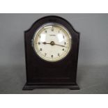 An early 20th century battery electric mantel clock by the Tempex company, arched top bakelite case,